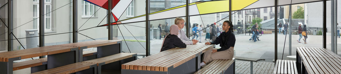 en gruppe mennesker som sitter ved et bord i en bygning
