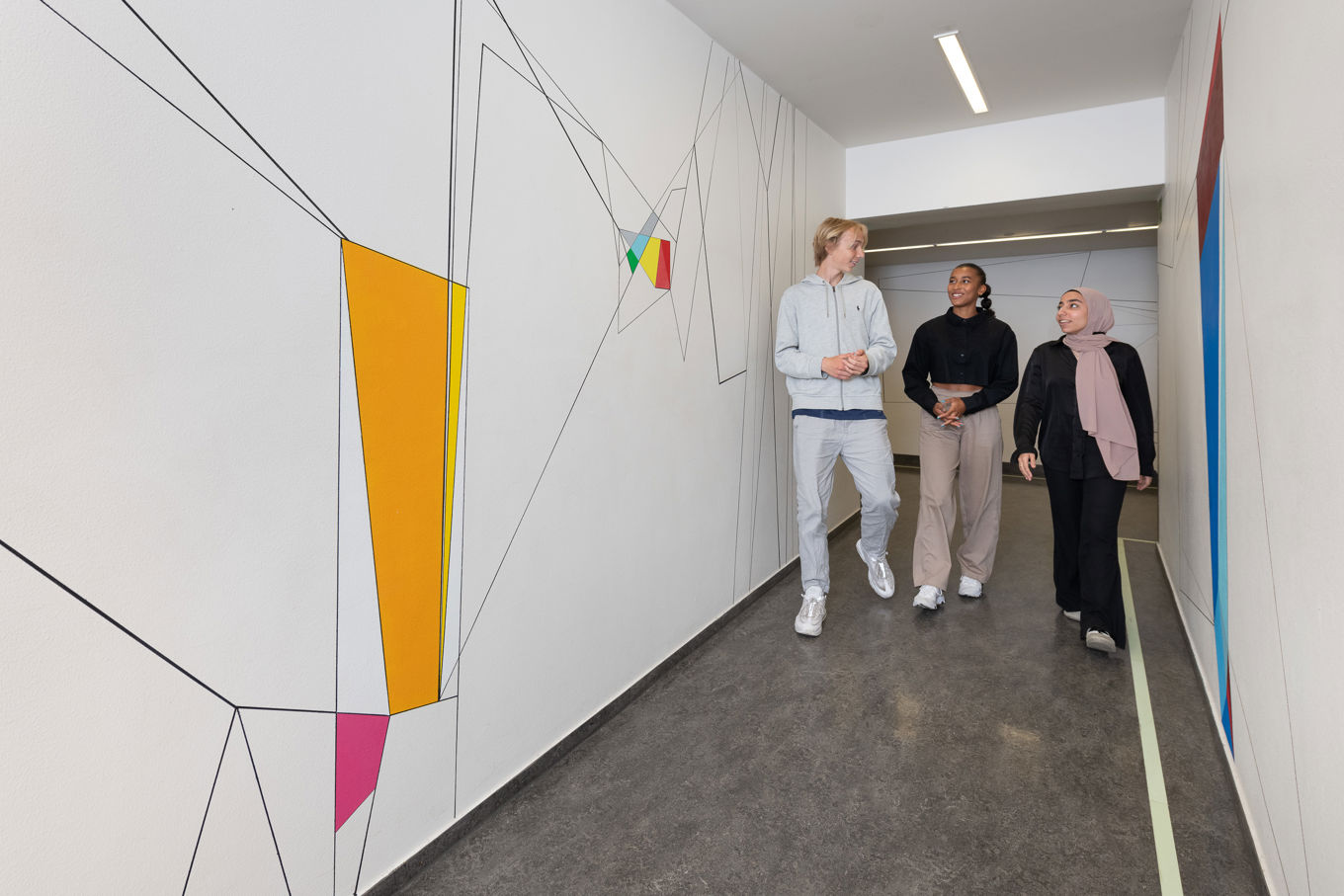 en gruppe personr som står i gangen